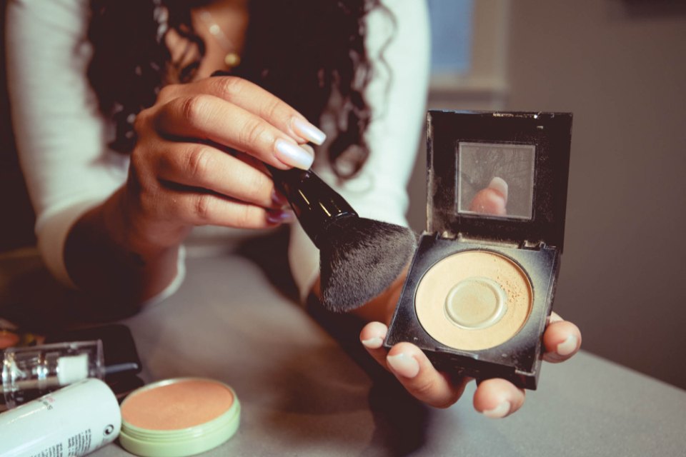 Vizážistka nanáší make-up štětcem